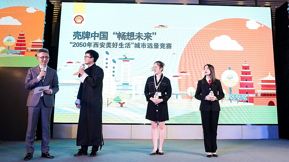 亚盈“畅想未来”远景挑战赛: 来自三所高校的学生团队(从左二起:,中国民航大学学生代表, 西安交通大学学生代表,上海理工大学中英国际学院学生代表)在台上与主持人蒋昌建互动
